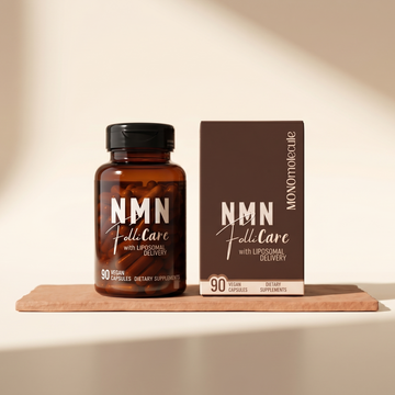 An amber supplement bottle labeled NMN FoliCare with a matching brown product box, displayed on a small wooden tray against a warm beige background with soft diagonal shadows.